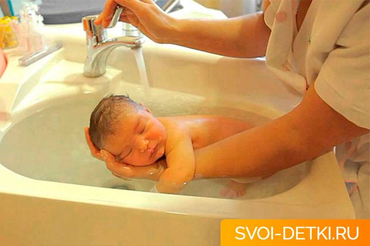 Как держать новорожденного при подмывании?